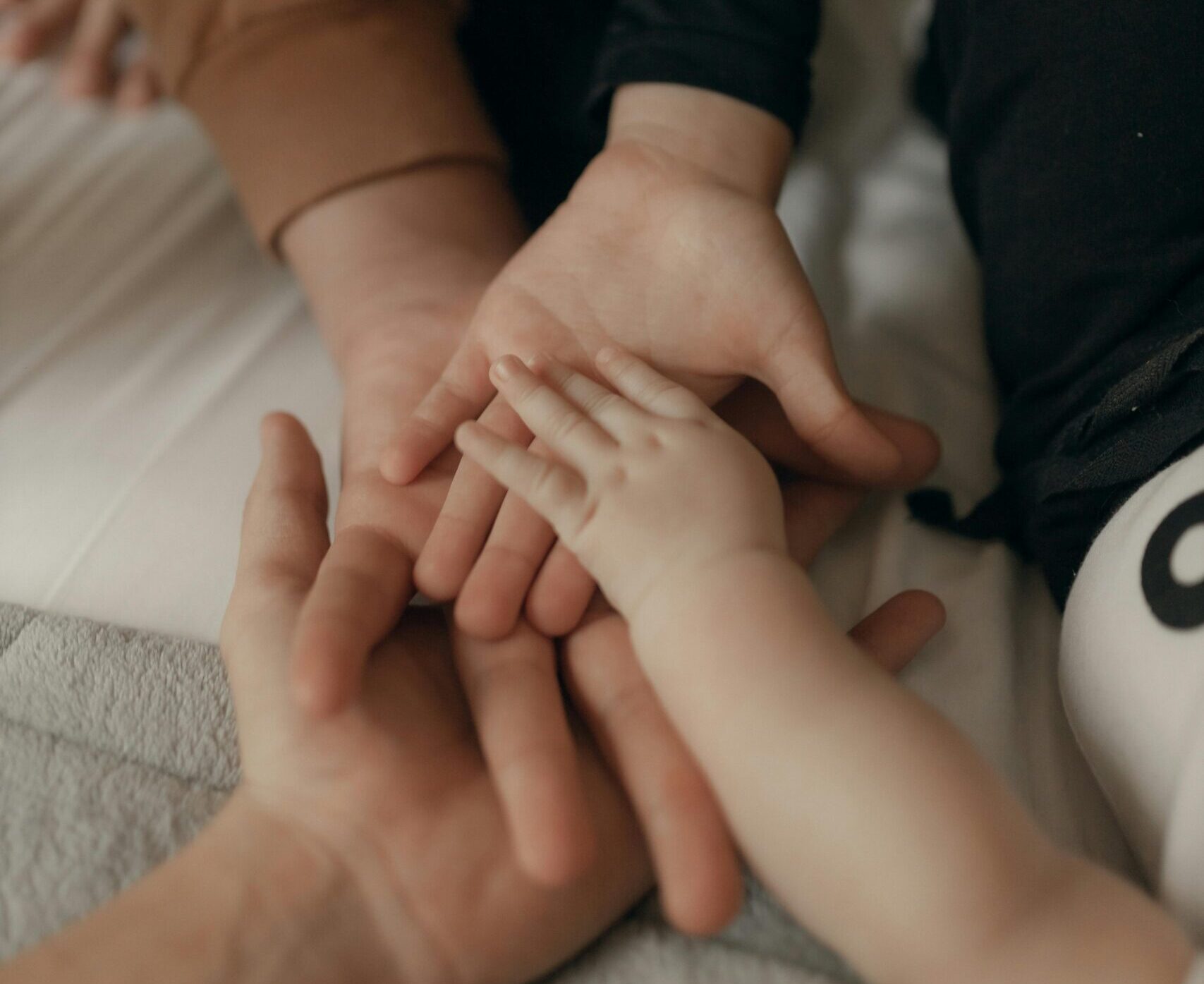 Close-up of a family joining hands, symbolizing unity and love.